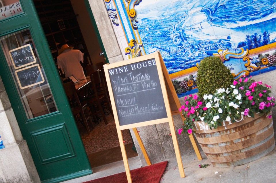 Wine shop entrance with sign advertising wine tasting and museum.