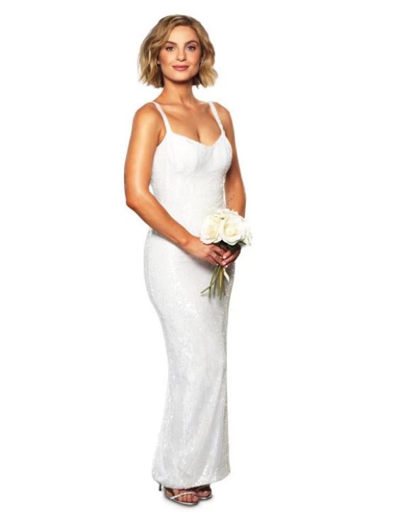 Woman in a white sequined gown holding a bouquet.