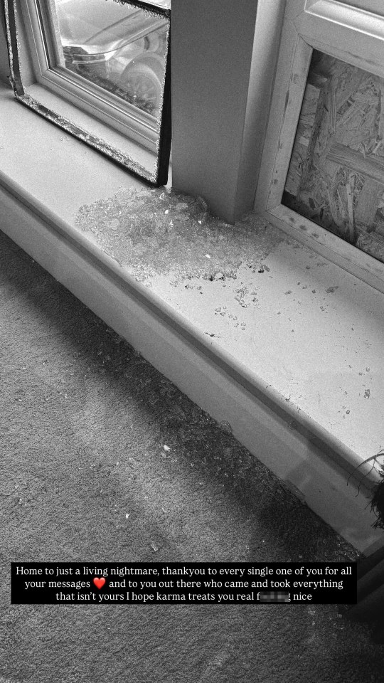 Black and white photo of broken window glass on the floor.