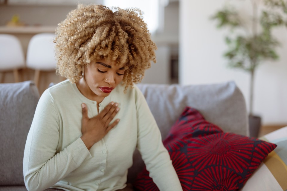 Woman holding her chest in pain.