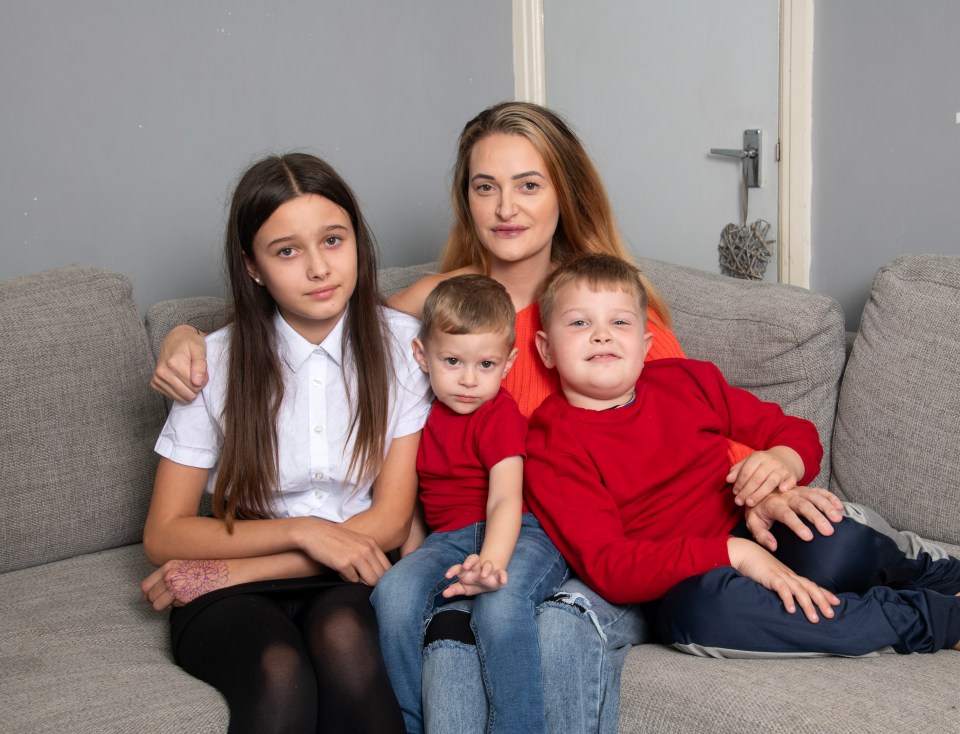 Mother with her three children sitting on a couch.