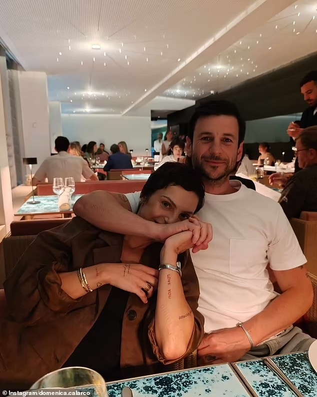 Domenica Calarco and Jarod Bogunovich embracing at a restaurant.