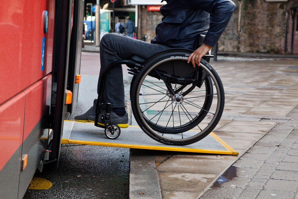 Person in wheelchair boarding a bus.