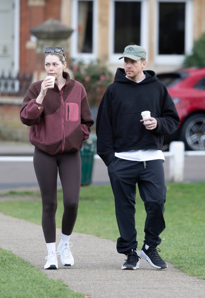 Danny and Georgia Jones walking and holding coffees.