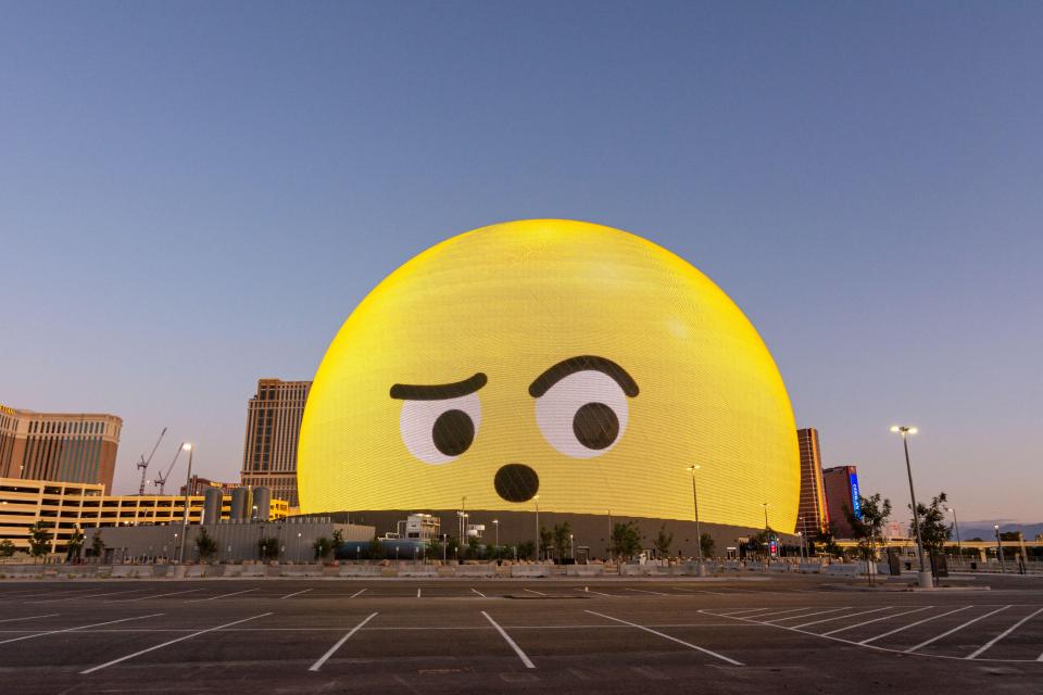 Large sphere-shaped building displaying a surprised emoticon.