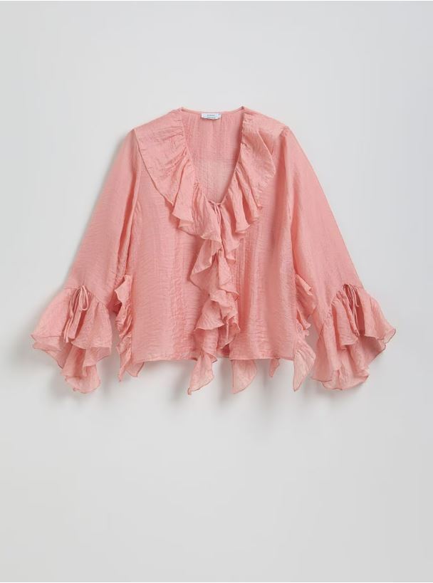 Pink ruffled blouse with three-quarter sleeves.