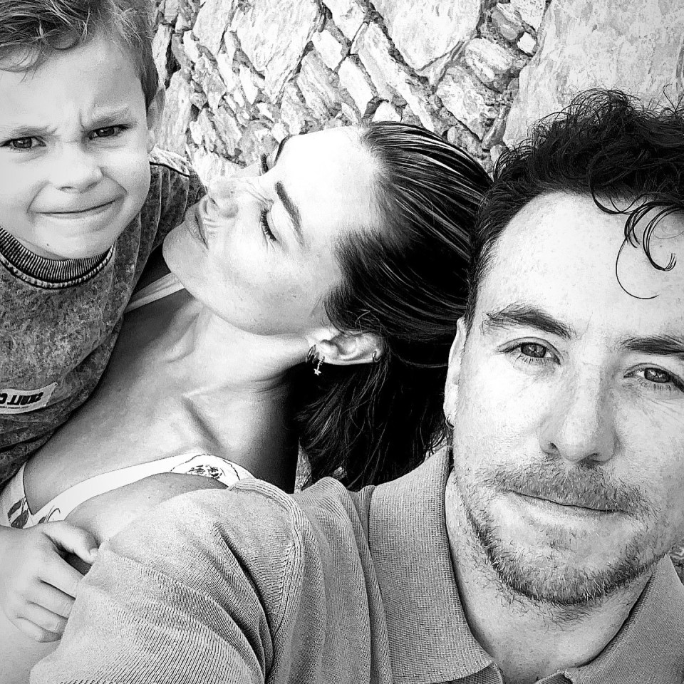 Black and white photo of Danny Jones, his wife Georgia, and their son.