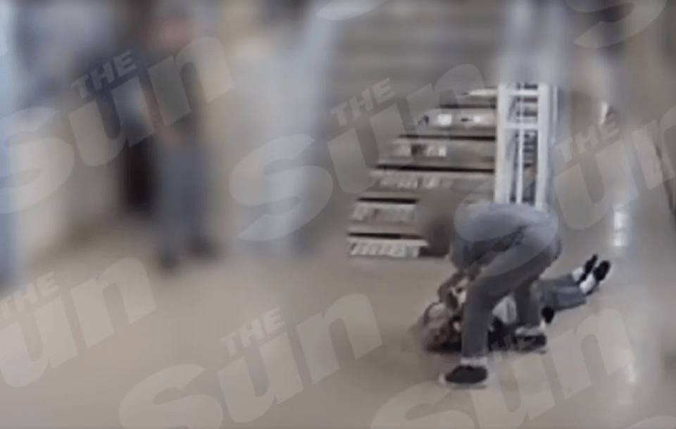 Security footage of a person being restrained on the floor.