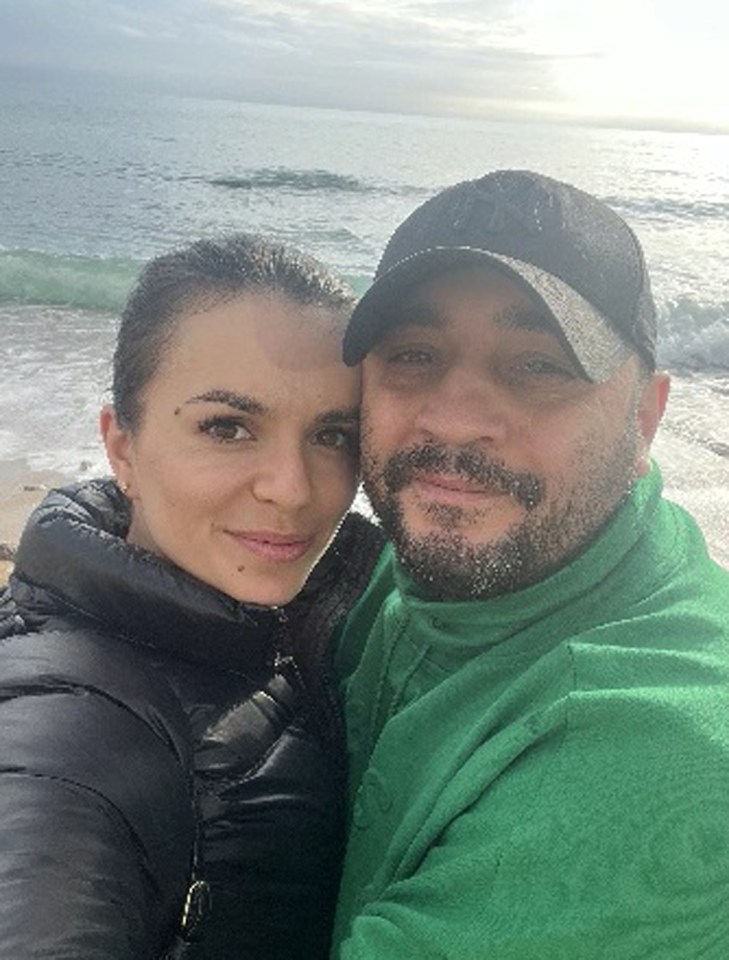 Couple posing for a selfie at the beach.