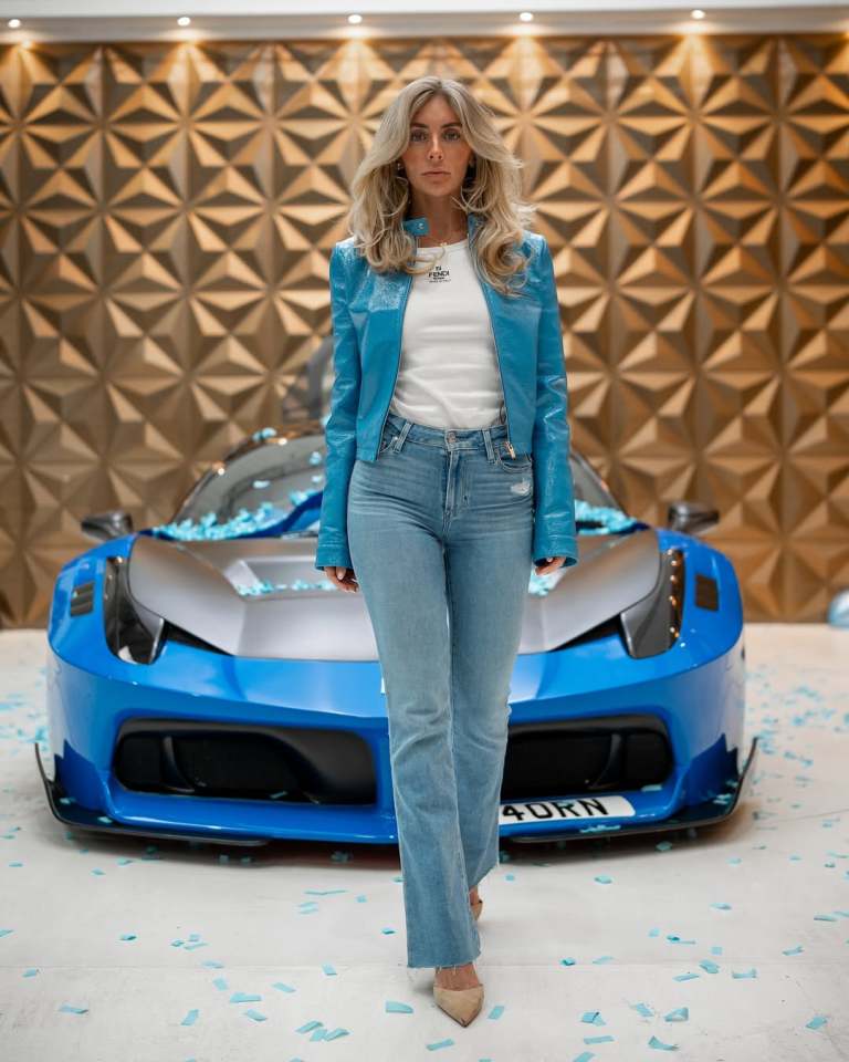 Woman standing in front of a blue Lamborghini.