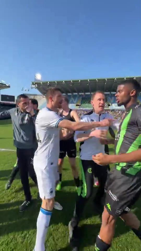 Soccer players arguing on a field after a game.