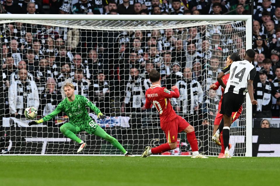 Alexander Isak of Newcastle United scoring a goal against Liverpool's goalkeeper.