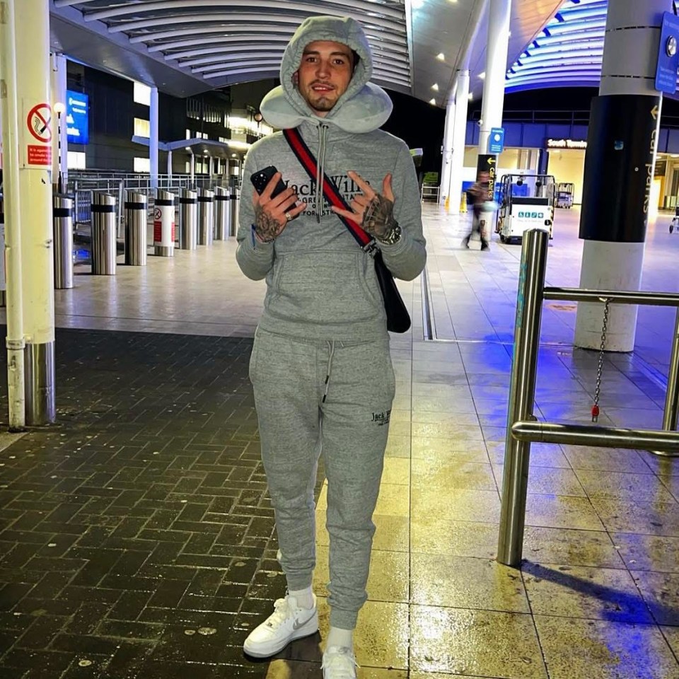 Man in gray tracksuit at an airport.