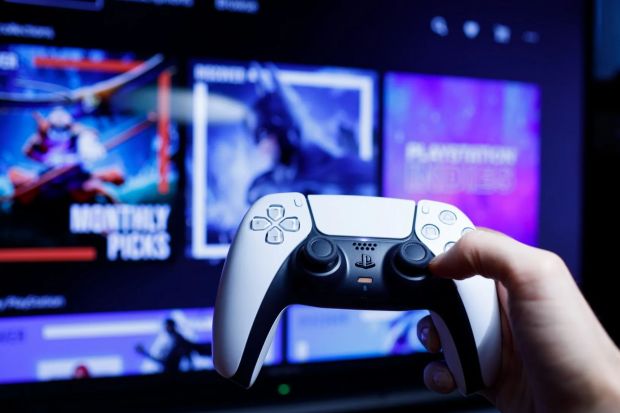 An image collage containing 1 images, Image 1 shows PlayStation 5 controller held in hand in front of a screen displaying games