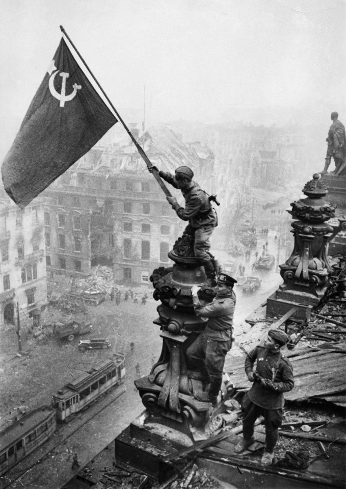 Red Army soldiers raising the Soviet flag over the Reichstag in Berlin.