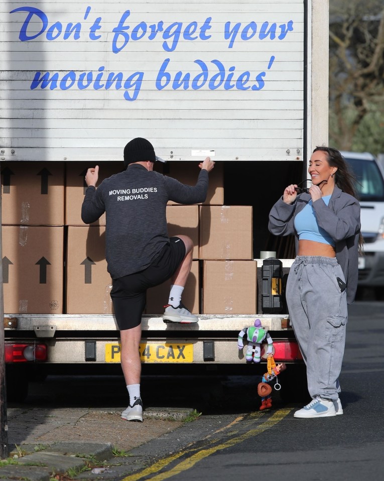 Woman and removal man loading boxes into a van.