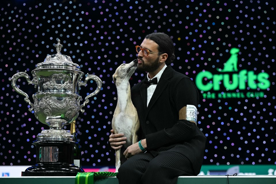 A whippet dog and its handler kiss after winning Best in Show at Crufts.